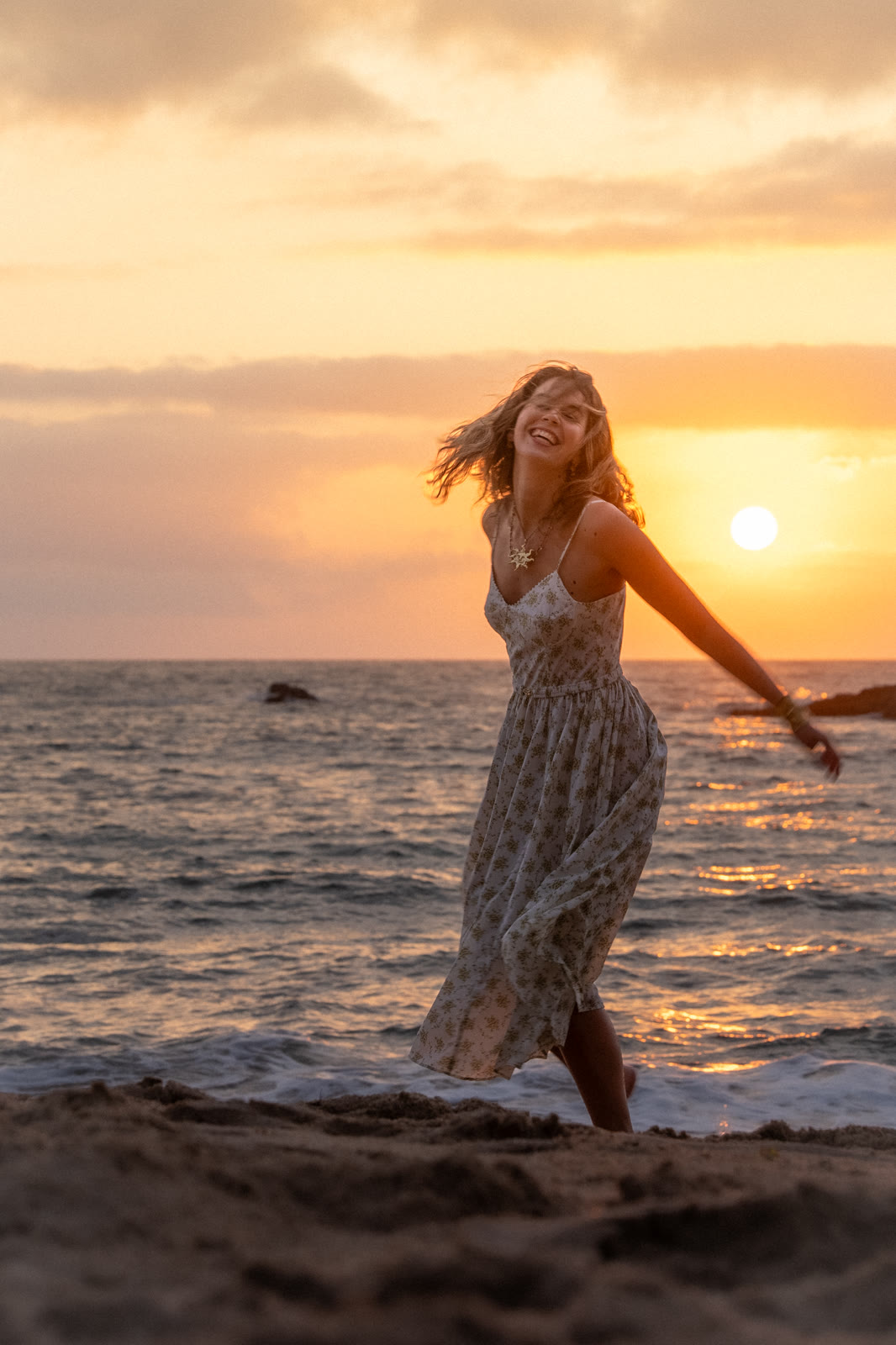 Woman dancing in the waves at sunset